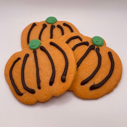 Three pumpkin-shaped cookies with chocolate stems and green buttons on a white background