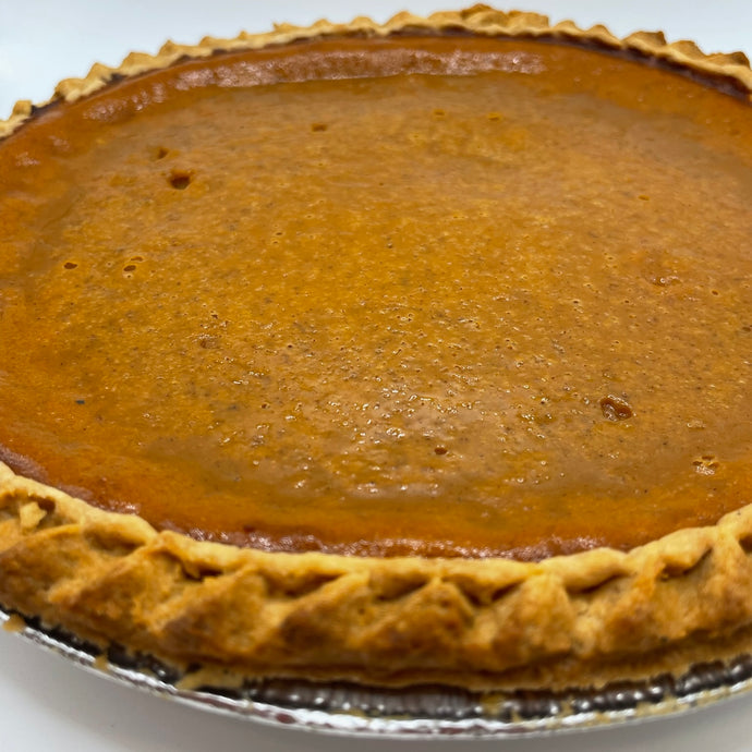 Pumpkin pie with a golden crust on a white background